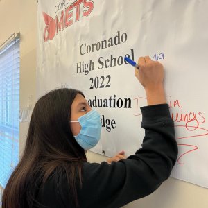 Coronado seniors read the “Graduation Pledge” and sign the banner